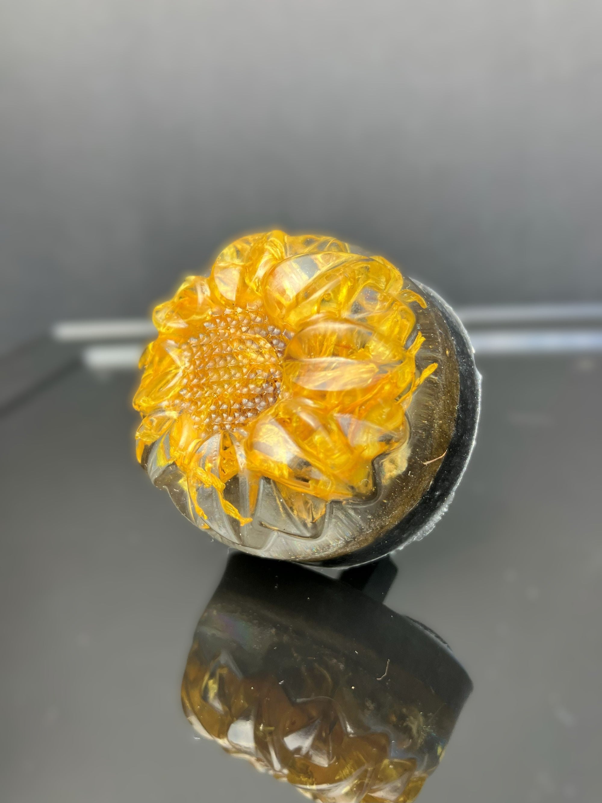 Handmade resin drawer knob showcasing a real calendula flower on a black background.